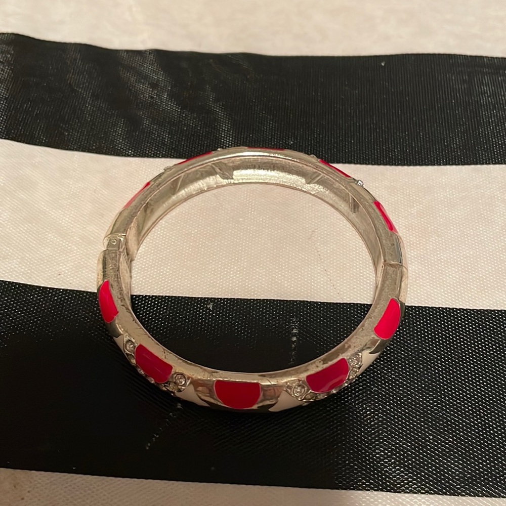 I am unsure of the brand but this red bracelet with hints of white